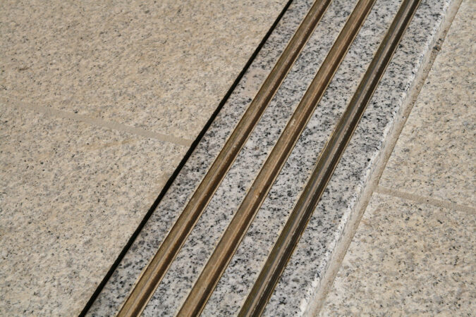 玄関敷居：御影石を使用し、真鍮のレール。たたきも御影石で掃きだし可能な作りです。